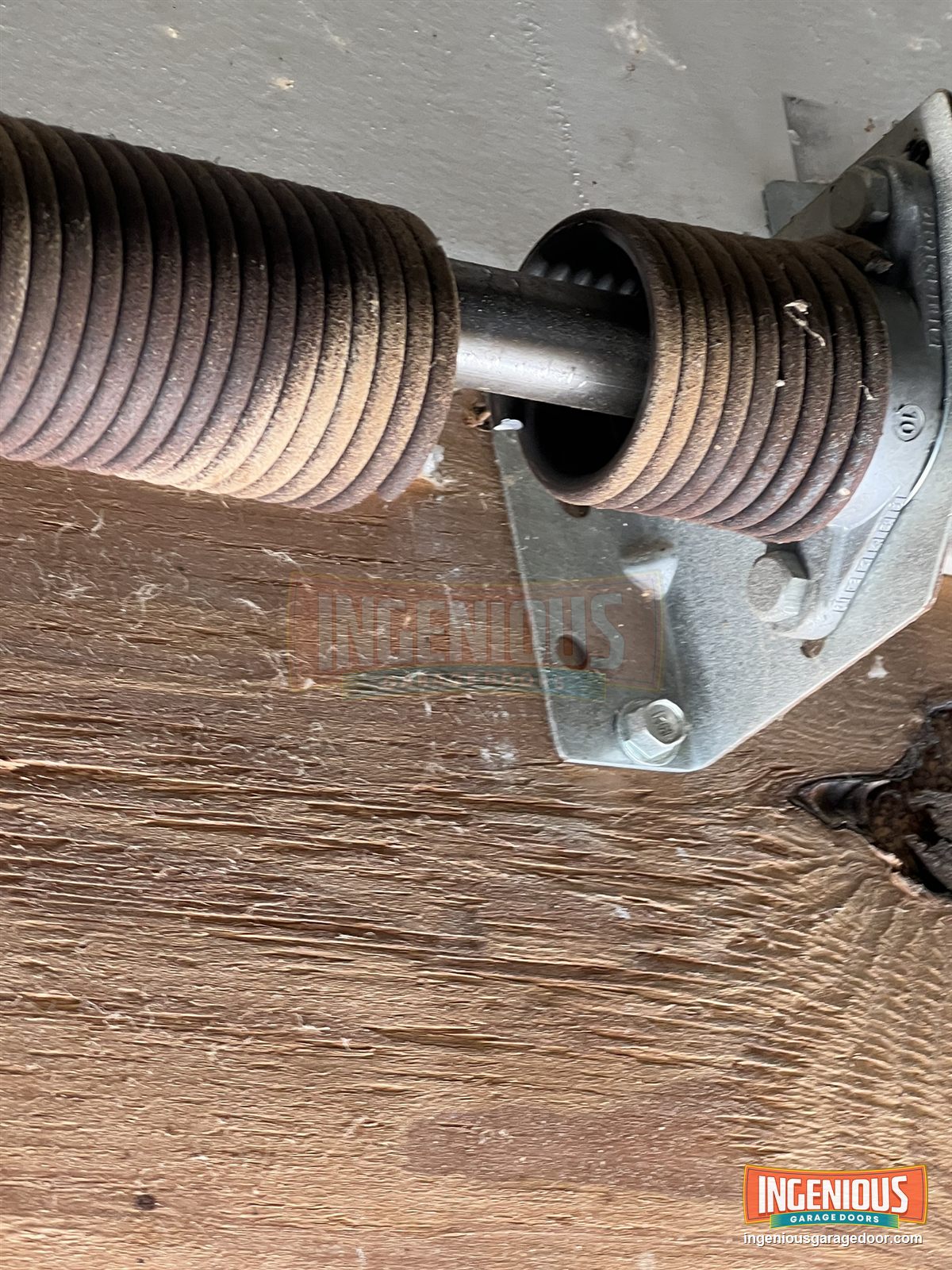The broken torsion spring. You can see the gap where the coil separated next to the center bracket.