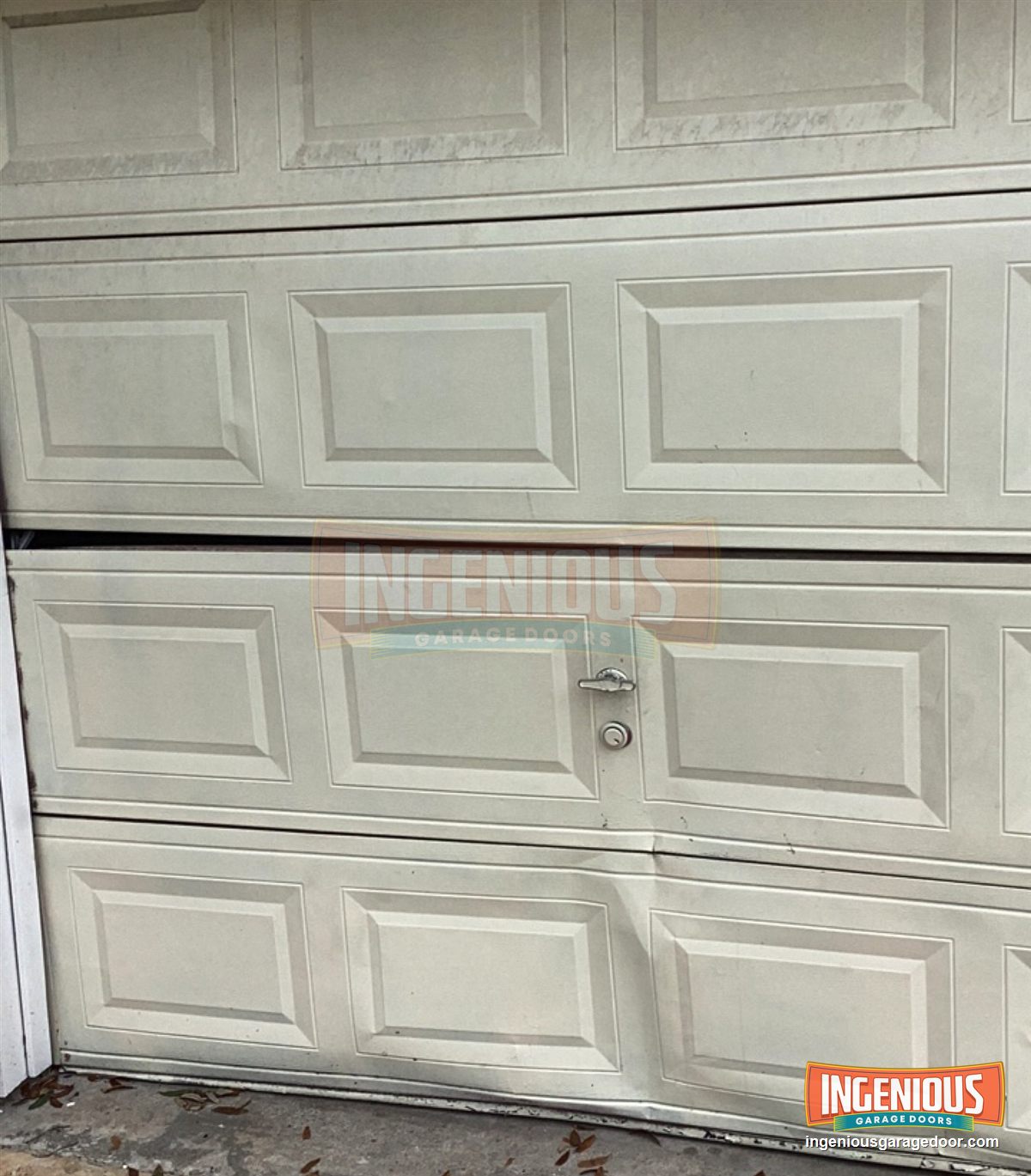 The door from the driveway. The bottom two sections are bowed and pulled apart at the seam.